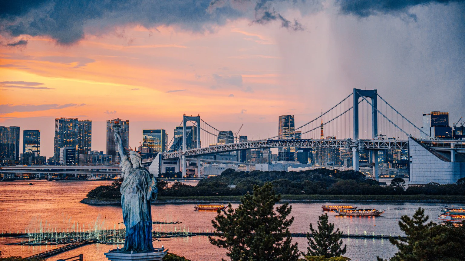 A statue facing Tokyo Bay beneath a warm evening sky